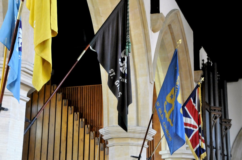 Uniformed group's flags hanging on the pillars in the church